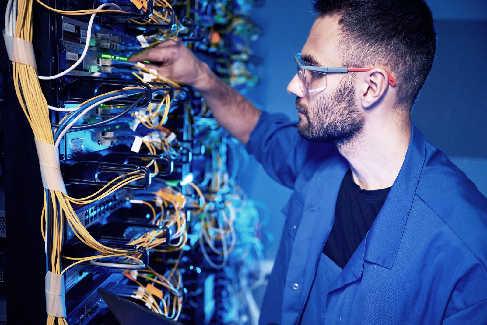 Technician configuring structured cabling on an enterprise network rack